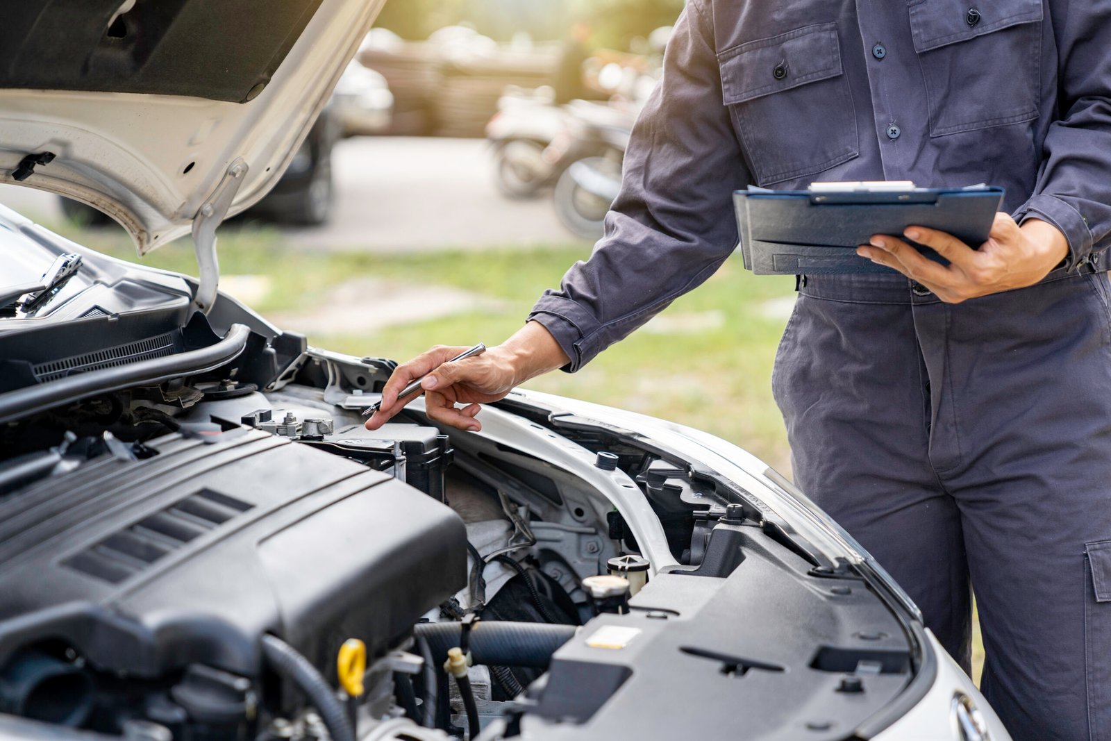 Mécanicien inspectant un moteur avec clipboard avant un long trajet Mécanicien inspectant un moteur avec clipboard avant un long trajet