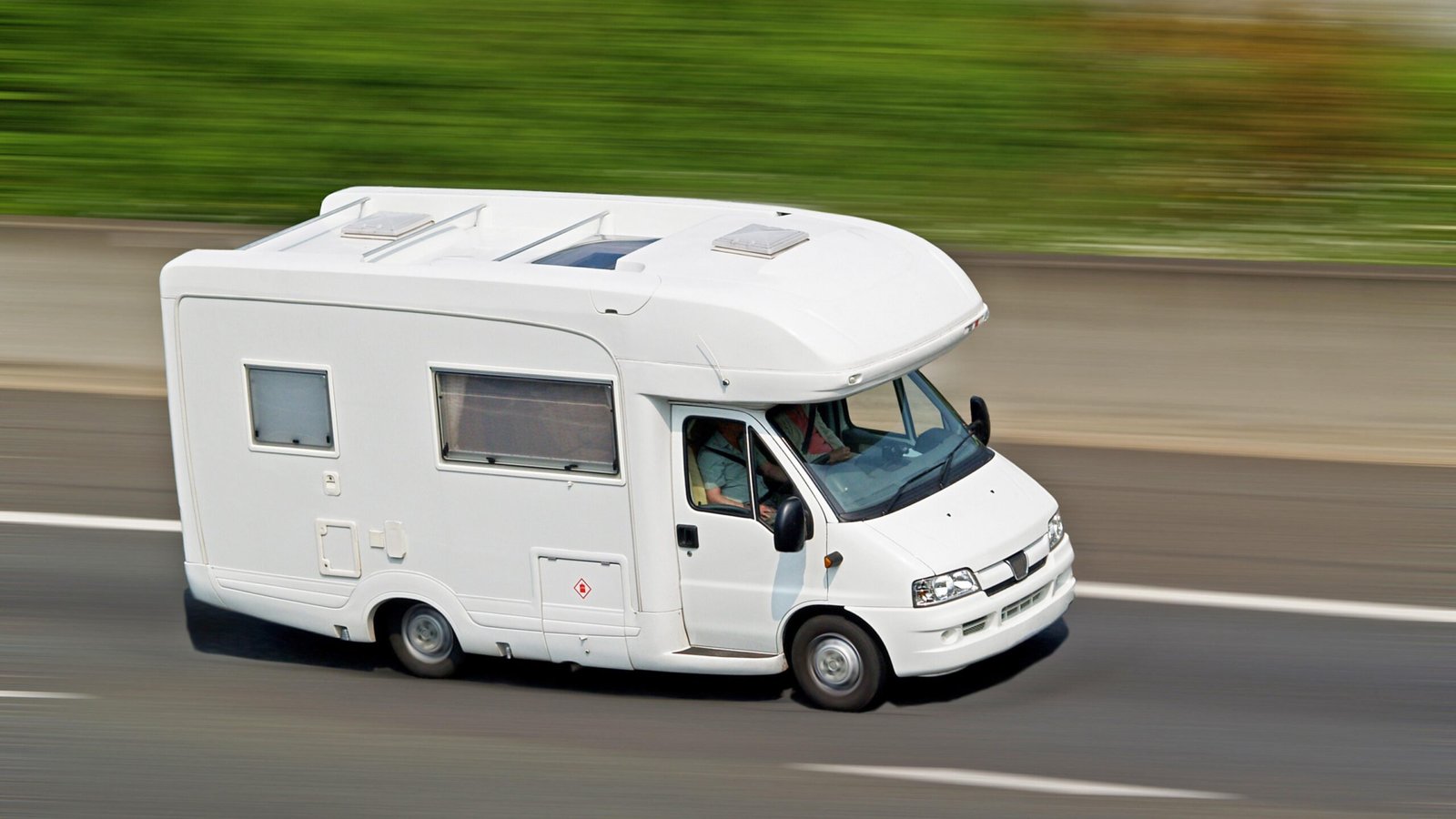 Camping-car roulant sur autoroute par une journée ensoleillée Camping-car roulant sur autoroute par une journée ensoleillée