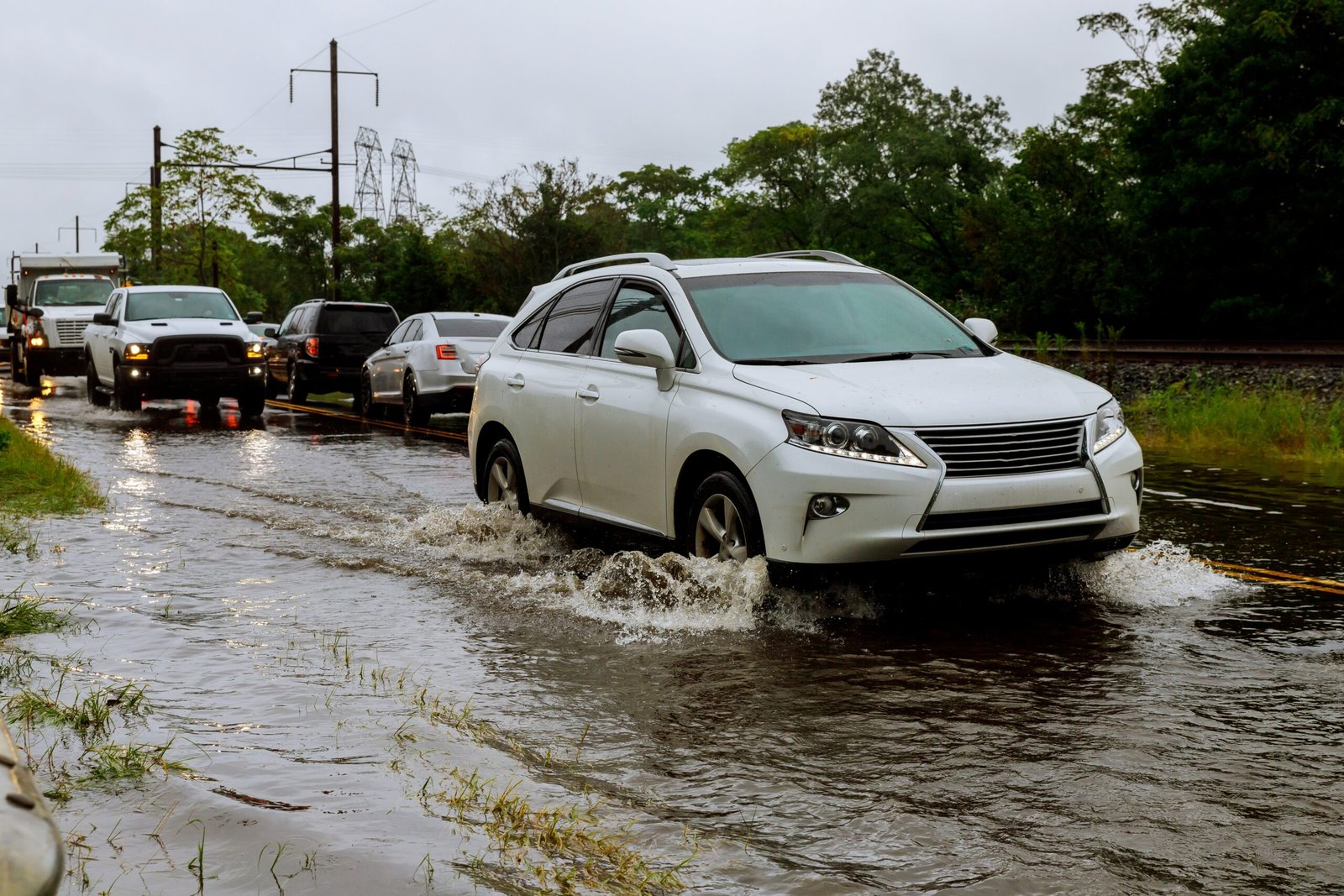 Voitures traversant une route inondée sous fortes pluies Voitures traversant une route inondée sous fortes pluies